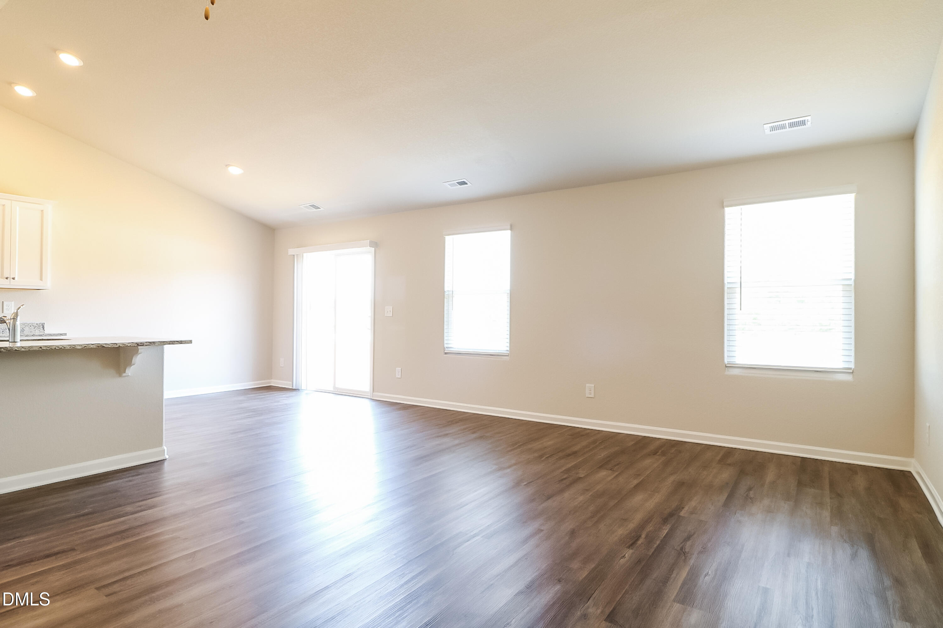 421 Brisk Drive Zebulon, NC 27597 - Photo 4 of 16 a view of an empty room with wooden floor and a window