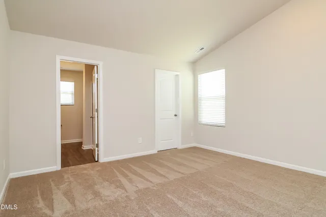 an empty room with windows and closet