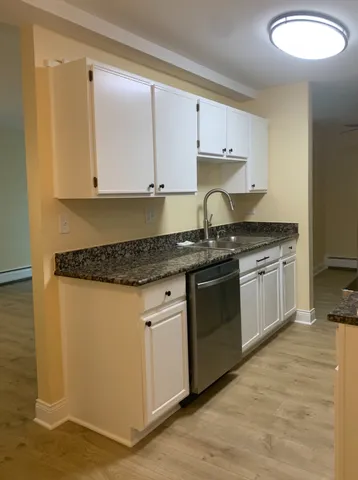 a kitchen with granite countertop white cabinets and white appliances
