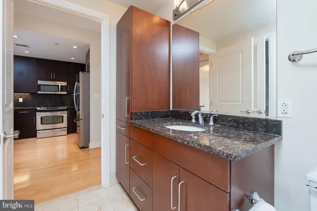 a bathroom with a granite countertop sink and a mirror