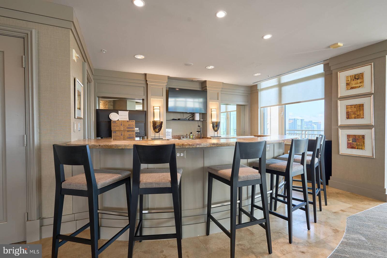 8220 Crestwood Heights Drive, Unit 714 McLean, VA 22102 - Photo 26 of 34 a kitchen with kitchen island granite countertop wooden cabinets and chairs