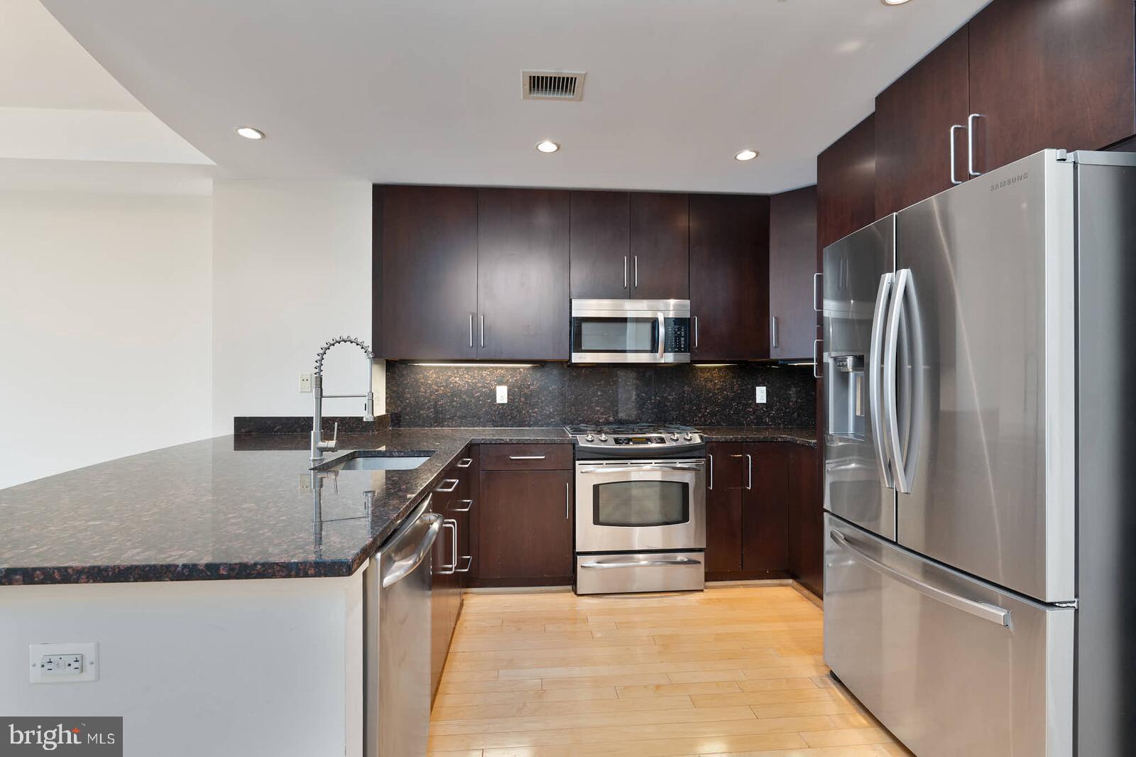 8220 Crestwood Heights Drive, Unit 714 McLean, VA 22102 - Photo 4 of 34 a kitchen with stainless steel appliances granite countertop a refrigerator a stove a sink and a microwave