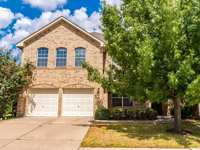 a view of house with garden and tall trees
