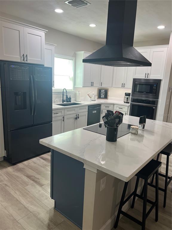 7746 Southeast 70th Avenue Trenton, FL 32693 - Photo 3 of 13 a kitchen with stainless steel appliances a kitchen island a stove a table and chairs
