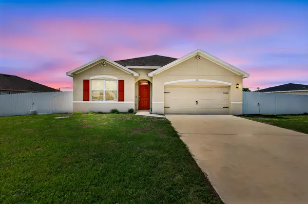 a view of a house with a yard and a garage