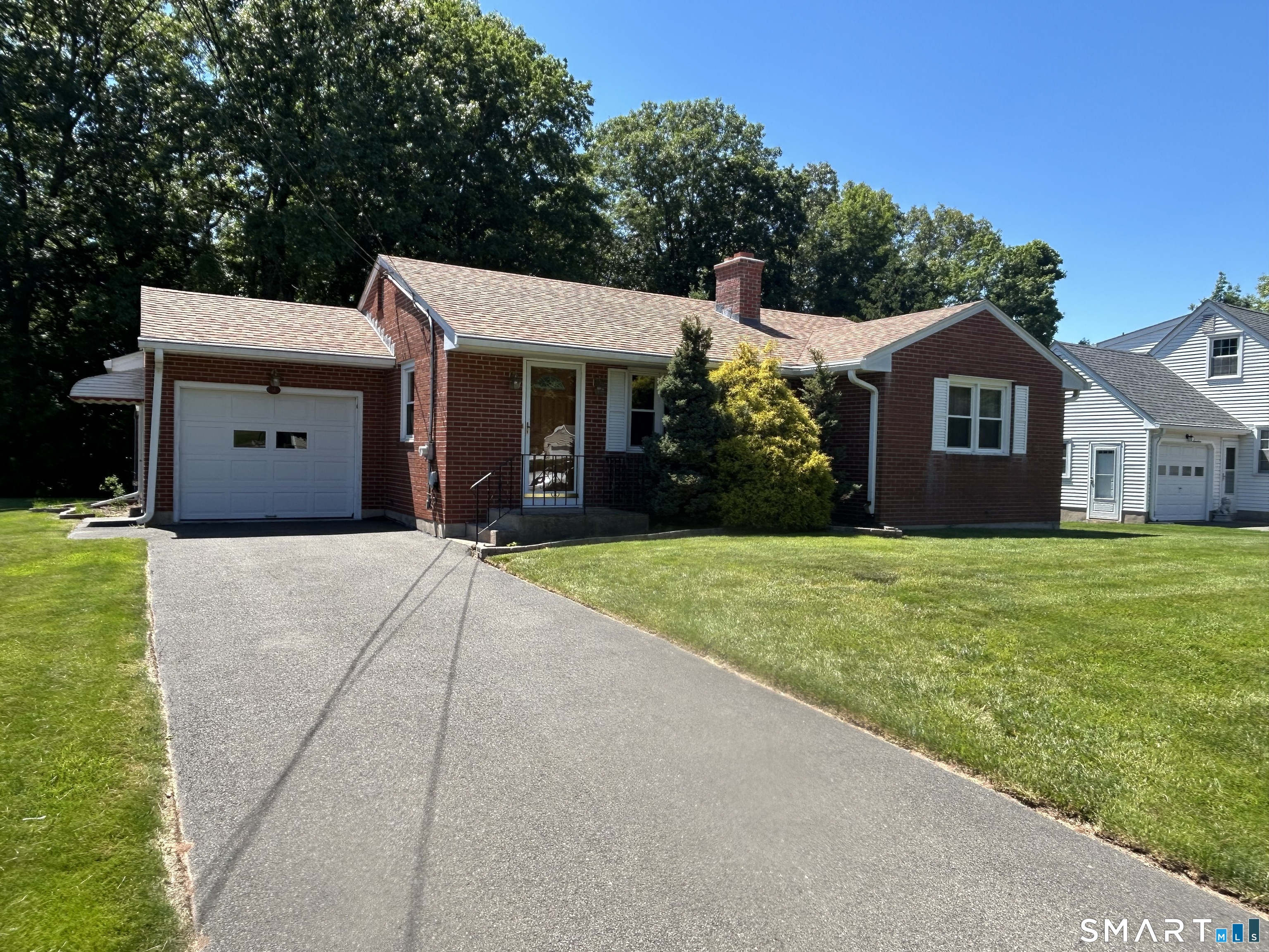 13 Walnut Lane Wallingford, CT 06492 - Photo 1 of 27 a front view of a house with a garden and trees