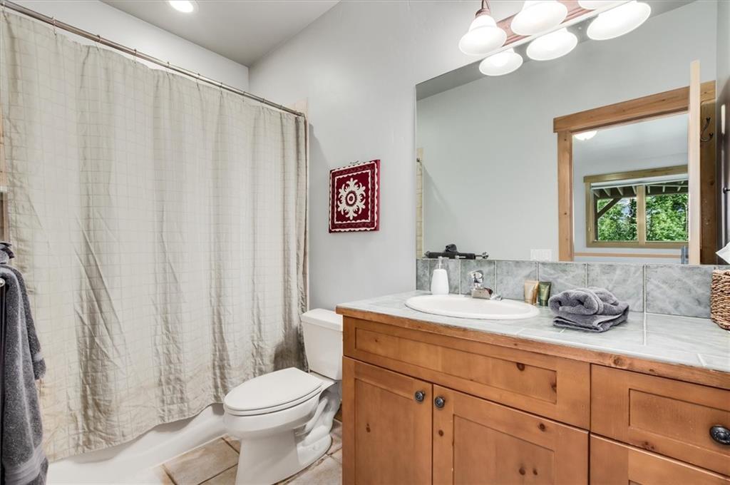 15 Rounds Road Breckenridge, CO 80424 - Photo 27 of 34 a bathroom with a sink a toilet a mirror and shower curtain