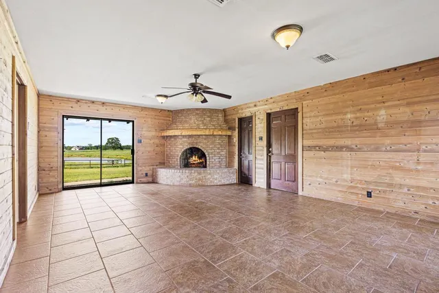 a view of an empty room with a fireplace and a window