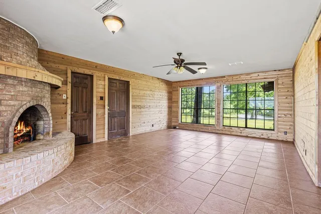 a view of empty room with fireplace and windows