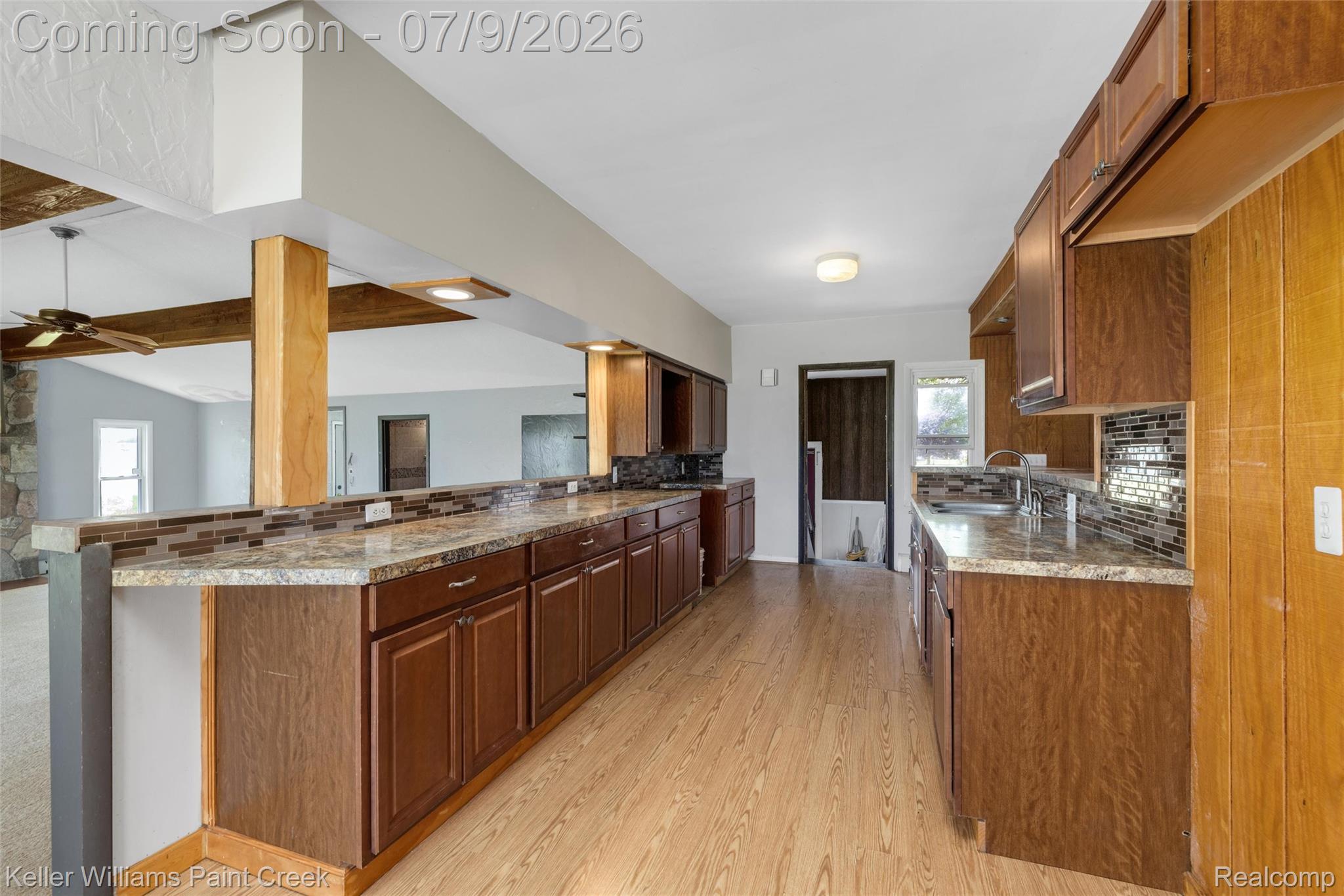 28780 School Section Road Richmond, MI 48062 - Photo 20 of 50 Kitchen featuring wood-finish flooring, dark wood cabinetry, and light-toned countertops with a mosaic tile backsplash