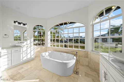 a spacious bathroom with a tub and large windows