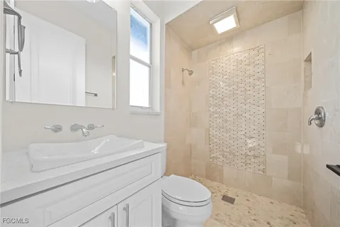 a bathroom with a sink a toilet and shower