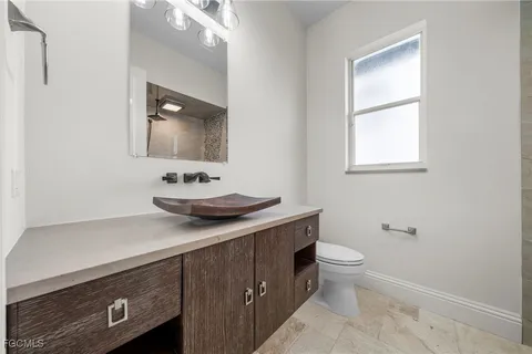 a bathroom with a sink a toilet and a mirror