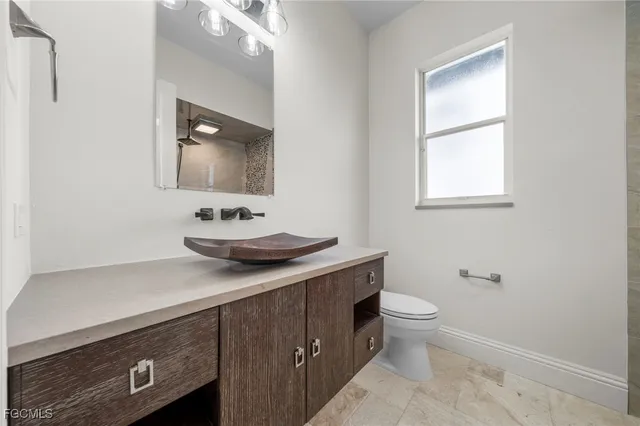 a bathroom with a sink a toilet and a mirror