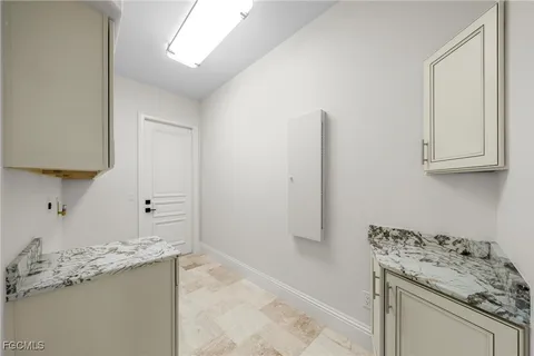 a room with kitchen island a sink stove and cabinets