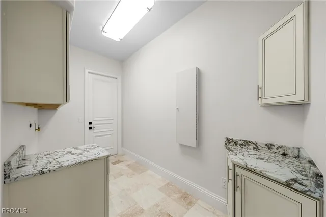 a room with kitchen island a sink stove and cabinets
