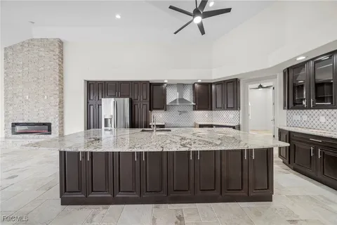 a large kitchen with kitchen island granite countertop a sink and a stove