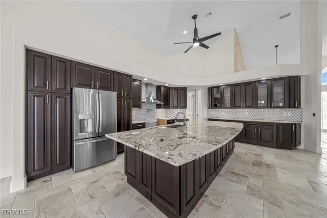 a kitchen with stainless steel appliances granite countertop a refrigerator and a sink
