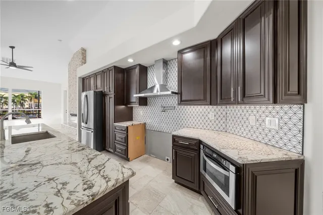 a kitchen that has a sink stainless steel appliances a refrigerator and a stove