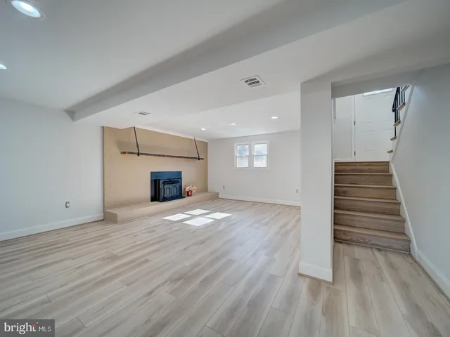 a view of empty room with wooden floor and fireplace