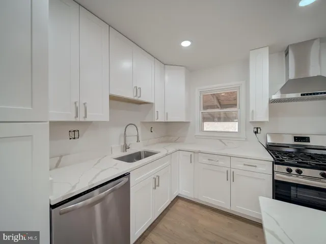 a kitchen with cabinets appliances a sink and a window