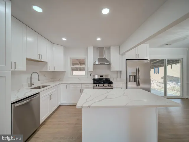 a kitchen with stainless steel appliances a sink stove and refrigerator