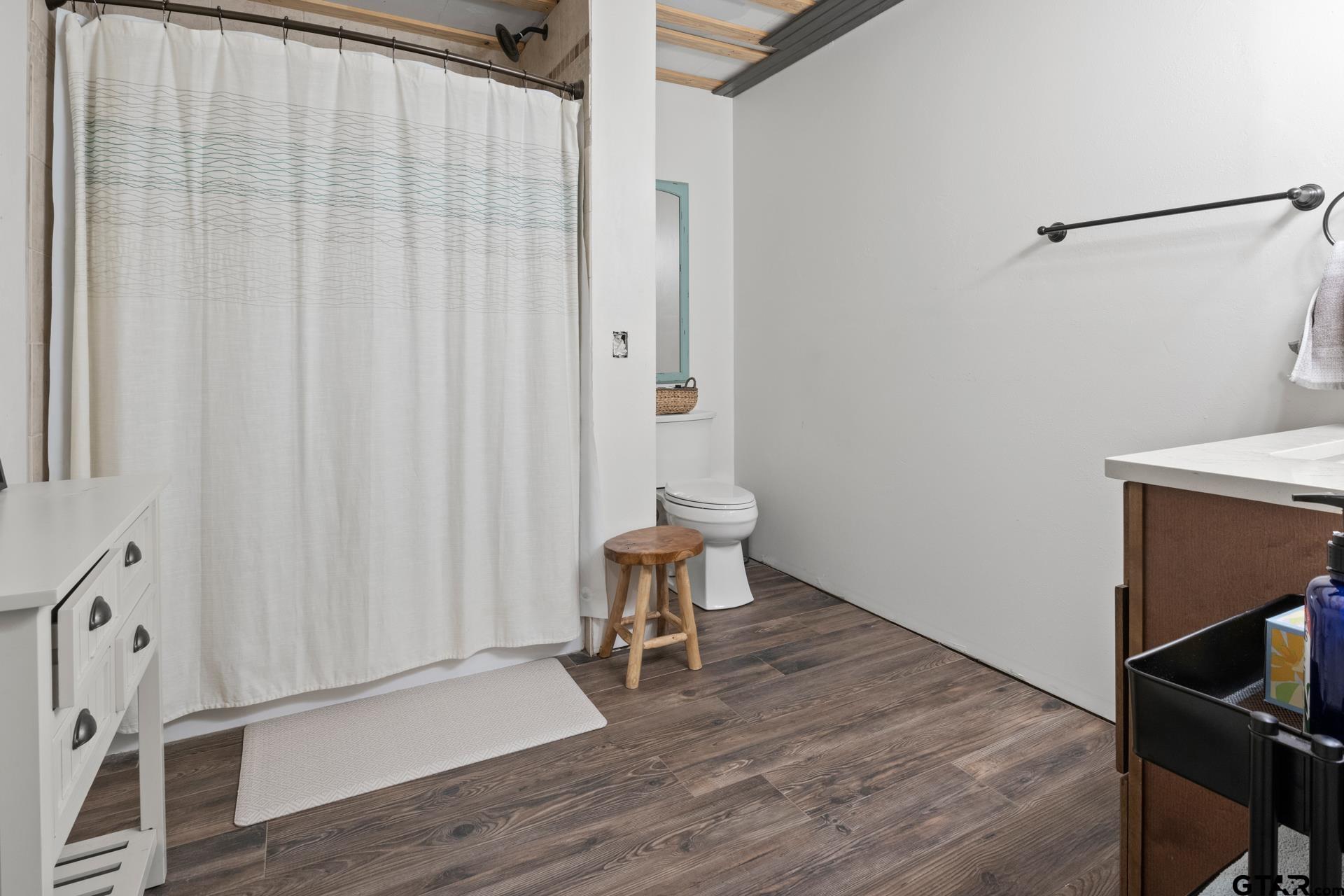 259 County Road 2407 Pittsburg, TX 75686 - Photo 16 of 42 a room with a chair and wooden floor