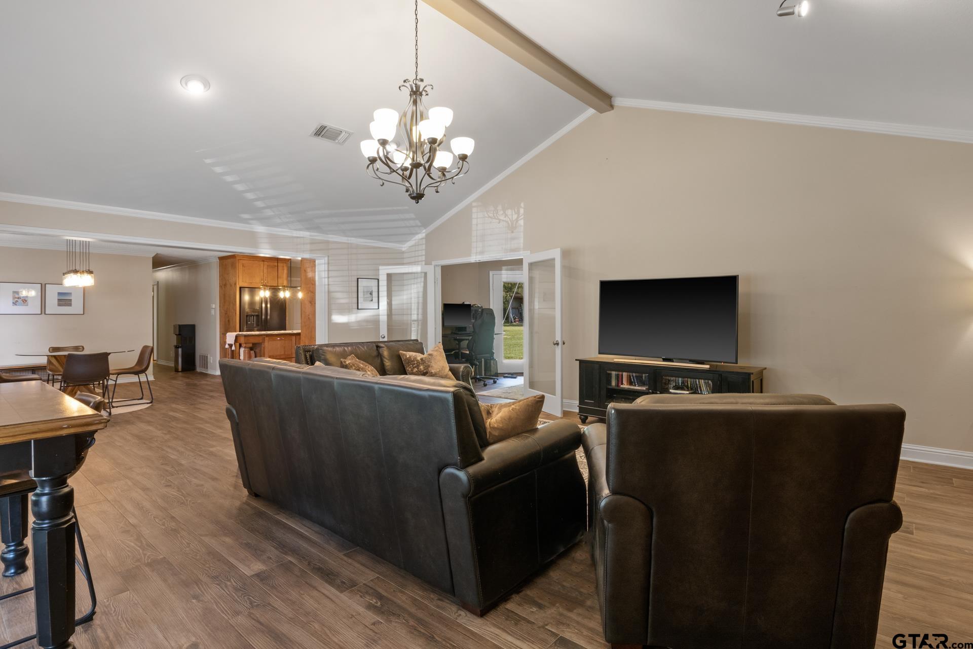 259 County Road 2407 Pittsburg, TX 75686 - Photo 21 of 42 a living room with furniture a flat screen tv and kitchen view