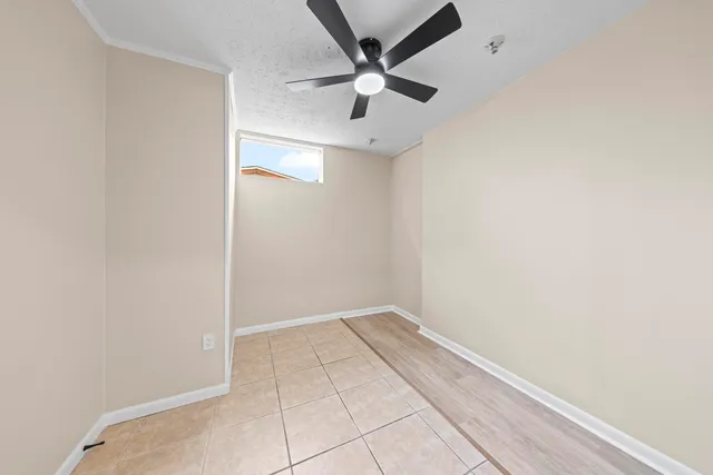 an empty room with a ceiling fan and carpet