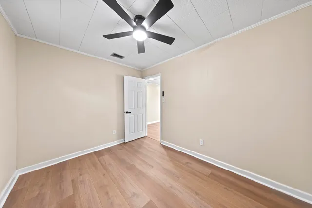an empty room with a window and a ceiling fan