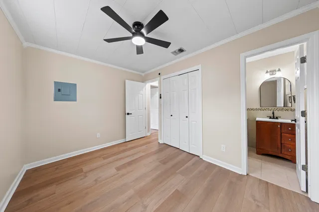 a view of a livingroom with a ceiling fan & a kitchen