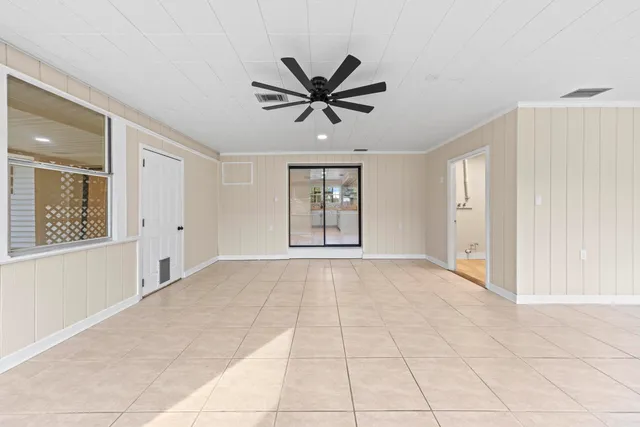 a view of a livingroom with a chandelier fan and windows