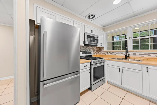 a kitchen with stainless steel appliances a refrigerator sink and microwave