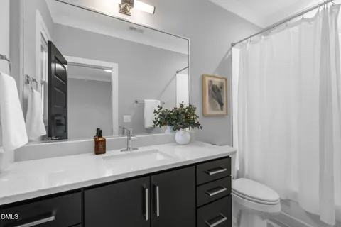 a bathroom with a sink a toilet and mirror