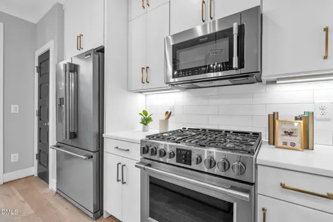 a kitchen with stainless steel appliances kitchen island granite countertop a stove a sink and a microwave