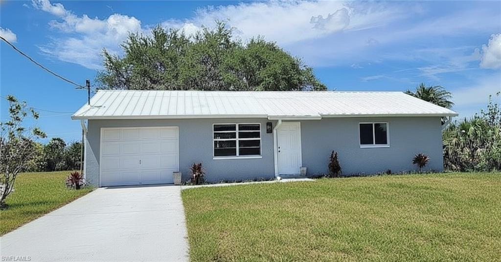 6143 Hester Avenue Fort Myers, FL 33905 - Photo 1 of 1 a front view of a house with a yard and garage