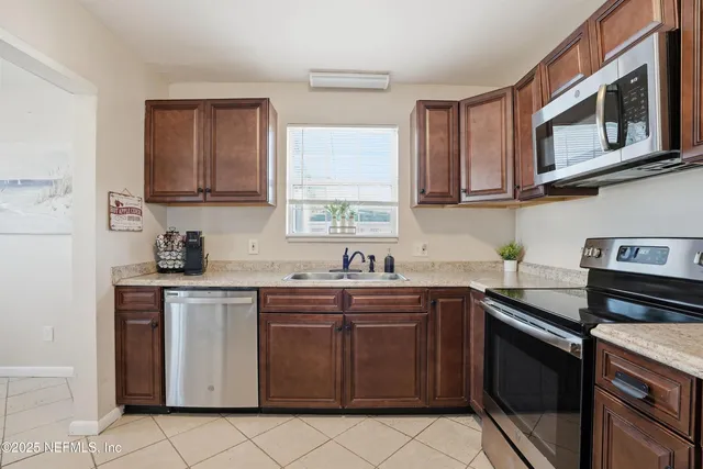a kitchen with stainless steel appliances granite countertop a refrigerator sink and stove