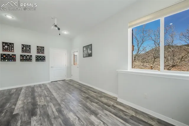 a view of empty room with wooden floor and fireplace