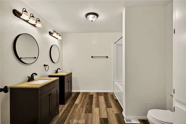 a view of a room with wooden floor and a ceiling fan