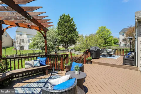 a view of a patio with couches chairs and wooden floor