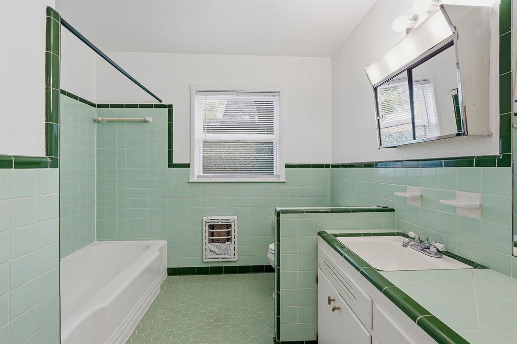 900 Stark Street Austin, TX 78756 - Photo 16 of 25 Mint green tile and hexagonal flooring define this cheerful bathroom, complete with a bathtub and vanity.
