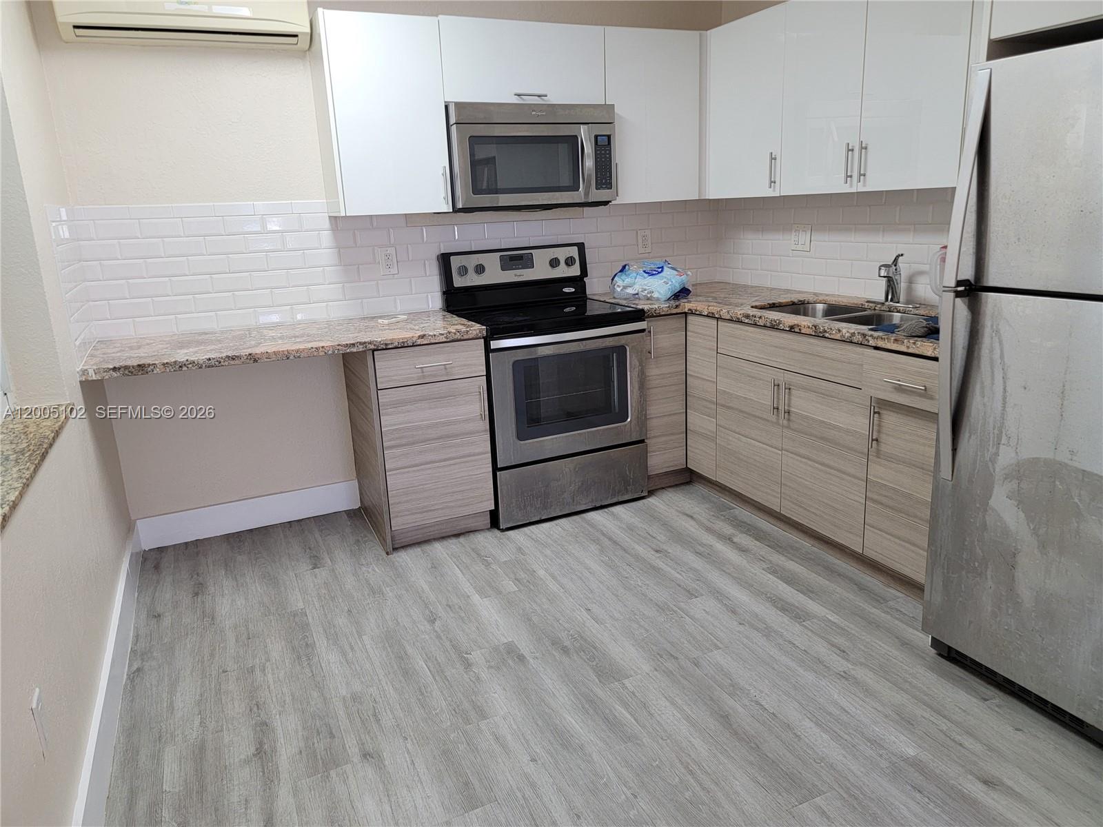 1736 Southwest 3rd Street, Unit 3 Miami, FL 33135 - Photo 1 of 10 a kitchen with granite countertop white cabinets and white appliances
