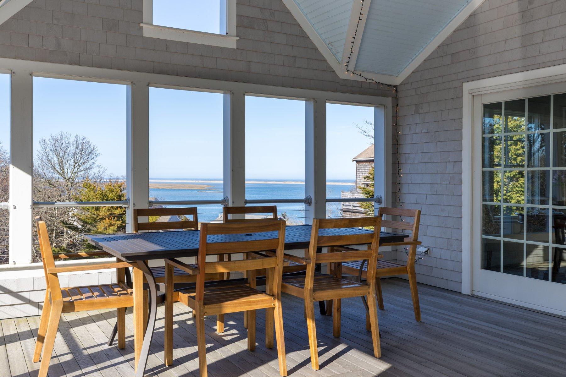 18 Snow Shore Road Orleans, MA 02653 - Photo 23 of 61 a view of a balcony dining table and chairs with wooden floor and fence