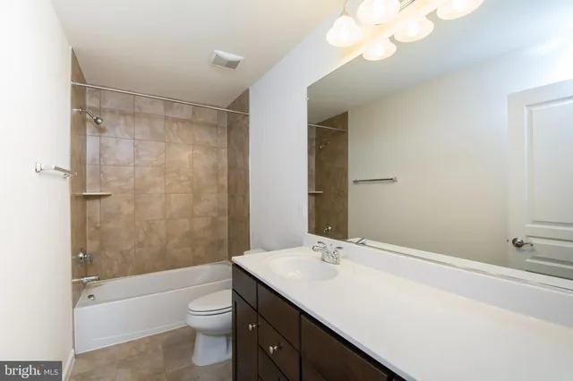 a bathroom with a sink a toilet a mirror and shower