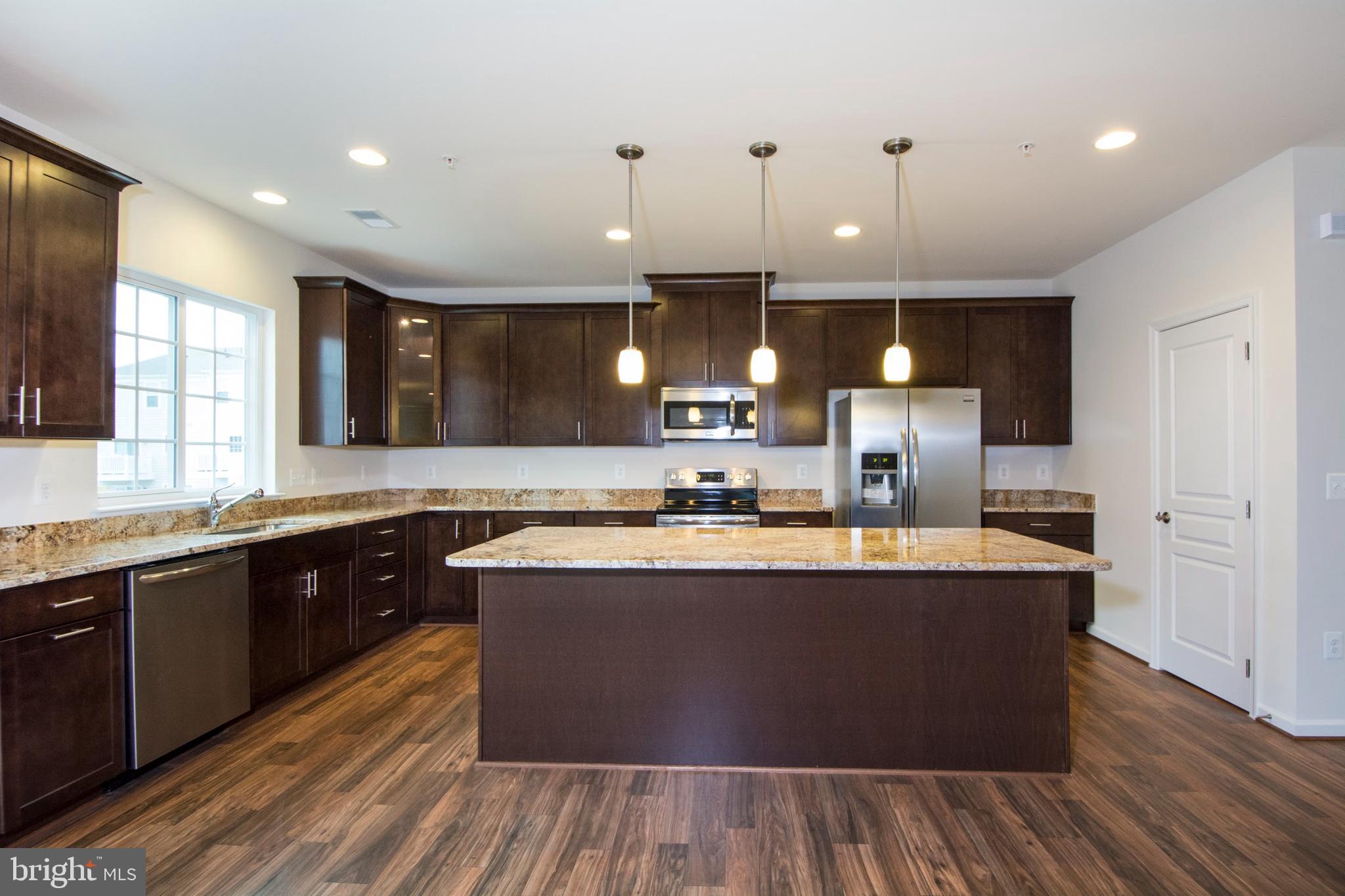 14894 Mason Creek Circle Woodbridge, VA 22191 - Photo 6 of 25 a large kitchen with stainless steel appliances a large counter top a sink a refrigerator and a window
