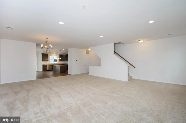 a view of an empty room with a kitchen