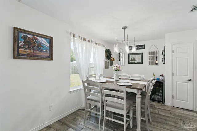a kitchen that has a lot of cabinets a sink stainless steel appliances and a chandelier