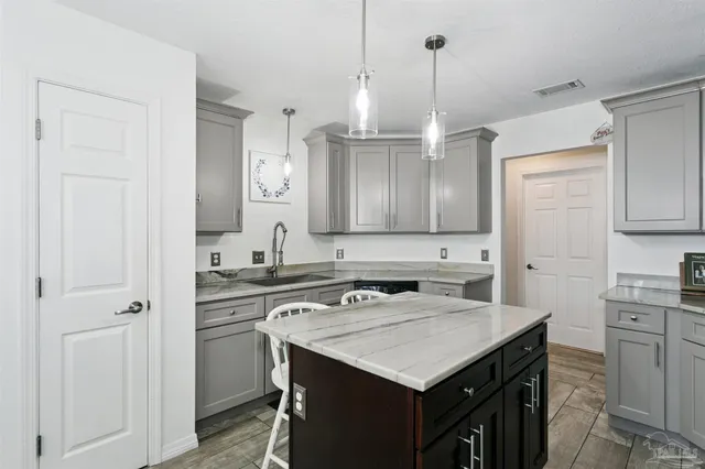 a kitchen with granite countertop a sink dishwasher stove and refrigerator with wooden floor