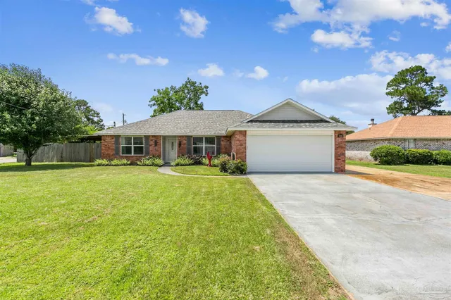 a front view of a house with yard and green space