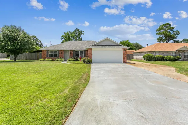 a front view of a house with a yard and potted plants